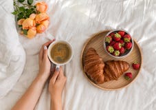 Woman`s hands holding a cup of coffee on the bed with white bedsheet. royalty free stock images Woman`s hands holding a cup of coffee on the bed with white bedsheet. royalty free stock images