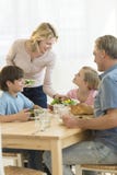 Woman Serving Food To Daughter At Dining Table stock photography Woman Serving Food To Daughter At Dining Table stock photography