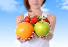 Woman showing apple, orange fruit and strawberries in hands in diet healthy nutrition concept