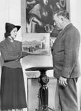 Woman showing an older man a piece of art royalty free stock images Woman showing an older man a piece of art royalty free stock images