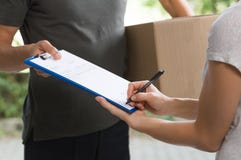 Woman signing delivery form stock photos Woman signing delivery form stock photos