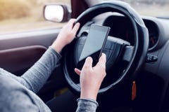Woman simultaneously driving car and reading text message Royalty Free Stock Image Woman simultaneously driving car and reading text message Royalty Free Stock Image