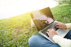 Woman Sit To Use Laptop At Park With Gold Light Royalty Free Stock Photos