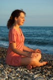 Woman Sits And Meditation Ashore Of Sea Stock Image