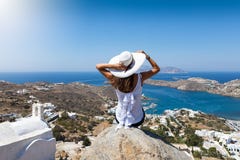 Woman sits on a rock high over the village of Ios island stock image Woman sits on a rock high over the village of Ios island stock image