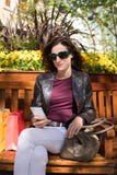 Woman sitting in bench using mobile Royalty Free Stock Photo Woman sitting in bench using mobile Royalty Free Stock Photo