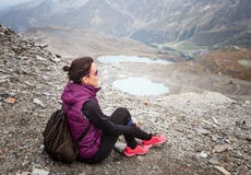 Woman sitting with her backpack looking at the landscape royalty free stock photography Woman sitting with her backpack looking at the landscape royalty free stock photography