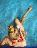 Woman sitting in the pool and using mobile phone Royalty Free Stock Photos Woman sitting in the pool and using mobile phone Royalty Free Stock Photos