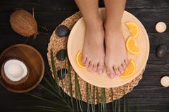 Woman Soaking Her Feet In Plate With Water And Orange Slices On Wooden Floor, Top View Royalty Free Stock Photos