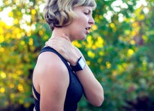 Woman in sportswear touching her neck by painful injury, over a royalty free stock images Woman in sportswear touching her neck by painful injury, over a royalty free stock images