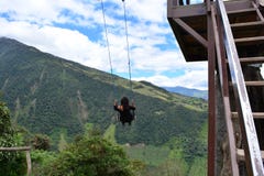 Woman swinging in the end-of-the-world swing in the town of Banos, Ecuador stock photo Woman swinging in the end-of-the-world swing in the town of Banos, Ecuador stock photo