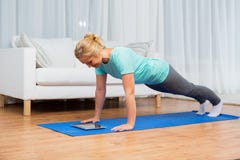 Woman with tablet pc doing plank exercise at home royalty free stock photography Woman with tablet pc doing plank exercise at home royalty free stock photography