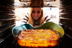Woman Taking Cooked Dish Of Lasagne Out Of The Oven Stock Photography Woman Taking Cooked Dish Of Lasagne Out Of The Oven Stock Photography