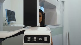 Woman undergoing panoramic x-ray exam, professional radiographic equipment