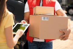 Woman Using App To Confirm Delivery Of Parcel From Courier Outdoors Stock Image