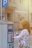 Woman using smartphone app to pay for parking Stock Photography Woman using smartphone app to pay for parking Stock Photography
