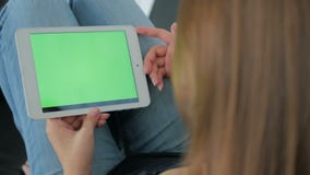 Woman using tablet computer with green screen