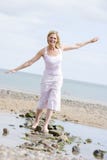Woman walking on beach path smiling stock photo Woman walking on beach path smiling stock photo