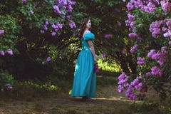 Woman is walking in the garden of lilac. stock photos Woman is walking in the garden of lilac. stock photos