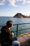 Woman watching at medieval fortress on coast near mediterranean town stock photo Woman watching at medieval fortress on coast near mediterranean town stock photo