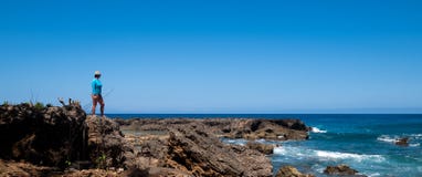 Woman stands on rocks overlooking the Pacific Ocean royalty free stock photo Woman stands on rocks overlooking the Pacific Ocean royalty free stock photo