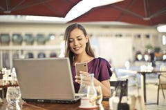 Woman Wearing Purple Shirt Holding Smartphone White Sitting on Chair Stock Photos Woman Wearing Purple Shirt Holding Smartphone White Sitting on Chair Stock Photos