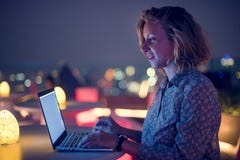 Woman working on a laptop at a rooftop bar Stock Photos Woman working on a laptop at a rooftop bar Stock Photos