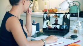 Woman works from home, videocalls her colleagues. Zoom, videocall , video conference, online meeting, working remotely
