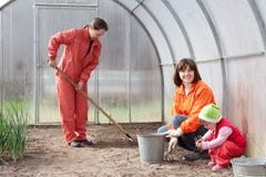 Women with child works at hothouse stock image Women with child works at hothouse stock image
