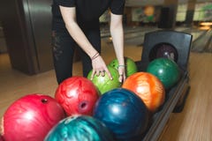 Women choose a bowling ball. Choosing colored balls for bowling stock photo Women choose a bowling ball. Choosing colored balls for bowling stock photo