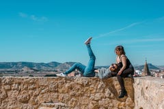 Women embrace and laugh while sitting on the castle stone royalty free stock image Women embrace and laugh while sitting on the castle stone royalty free stock image