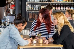 Women Looking At Friend Using Mobile Phone In Cafe royalty free stock photo Women Looking At Friend Using Mobile Phone In Cafe royalty free stock photo