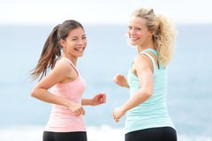 Women running exercising smiling on beach Stock Photo Women running exercising smiling on beach Stock Photo