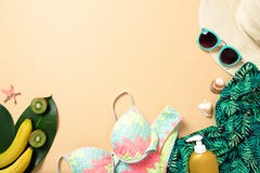 Women`s beach accessories: straw hat, sunglasses, swimwear, green scarf, suntan lotion, banana on yellow background. Travel royalty free stock image Women`s beach accessories: straw hat, sunglasses, swimwear, green scarf, suntan lotion, banana on yellow background. Travel royalty free stock image