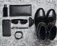 Women's boots, accessories, gadgets for a business lady layout on a concrete surface. Perfume bottle, purse, pen, smartphone stock photo Women's boots, accessories, gadgets for a business lady layout on a concrete surface. Perfume bottle, purse, pen, smartphone stock photo