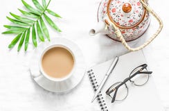 Women`s Flat Lay Table With A Cup Of Milk Tea, Teapot And Clean Empty Notebook On A Light Background, Top View. Royalty Free Stock Photos Women`s Flat Lay Table With A Cup Of Milk Tea, Teapot And Clean Empty Notebook On A Light Background, Top View. Royalty Free Stock Photos