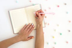 Women s hands with pen on note pad and colorful balls on the table . Stylish trendy color female manicure stock images Women s hands with pen on note pad and colorful balls on the table . Stylish trendy color female manicure stock images