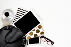 Women`s office desk on white background touch pad tablet gadget cellphone with gold stylish books black handbag, top stock photography Women`s office desk on white background touch pad tablet gadget cellphone with gold stylish books black handbag, top stock photography