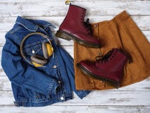 Womens clothing, accessories, footwear burgundy boots, yellow wireless headphones, denim jacket, suede skirt. Fashion outfit. royalty free stock photography Womens clothing, accessories, footwear burgundy boots, yellow wireless headphones, denim jacket, suede skirt. Fashion outfit. royalty free stock photography