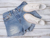 Womens clothing, shoes white sneakers, denim shorts. Fashion outfit, spring summer collection. Shopping concept. Flat lay, view stock photos Womens clothing, shoes white sneakers, denim shorts. Fashion outfit, spring summer collection. Shopping concept. Flat lay, view stock photos