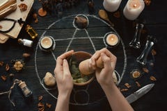 ⁶Womens hands make love potion on pentagram circle with candles, stones and old books on witch table. Occult, esoteric or