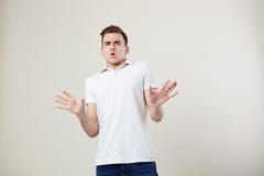 Wondered guy dressed in a white t-shirt and jeans is on a white background in the studio royalty free stock image Wondered guy dressed in a white t-shirt and jeans is on a white background in the studio royalty free stock image