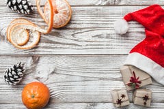 Wooden background. White. Winter card. Mandarins. Pinecone. His Santa`s hat. Space for greeting card with Christmas or New Year. Stock Photo Wooden background. White. Winter card. Mandarins. Pinecone. His Santa`s hat. Space for greeting card with Christmas or New Year. Stock Photo