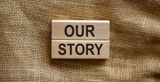 Wooden blocks form the text `our story` on beautiful canvas background. Business concept