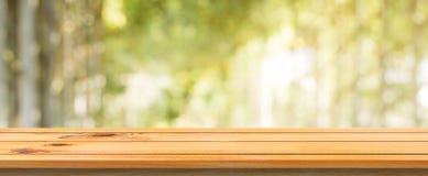 Wooden board empty table blurred background. Perspective brown wood table over blur trees forest background. Royalty Free Stock Photography Wooden board empty table blurred background. Perspective brown wood table over blur trees forest background. Royalty Free Stock Photography