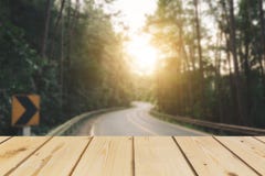 Wooden Board Empty Table In Front Of Blurred Background. Perspective Brown Wood Over Road Is Surrounded By Pine Trees Forest To Th Stock Images Wooden Board Empty Table In Front Of Blurred Background. Perspective Brown Wood Over Road Is Surrounded By Pine Trees Forest To Th Stock Images