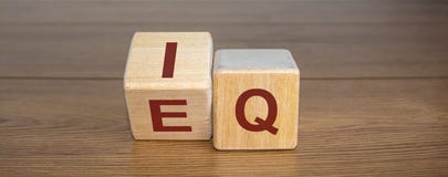 Wooden cubes with the expression `IQ` `Intelligence Quotient` to `EQ` `Emotional Intelligence Quotient