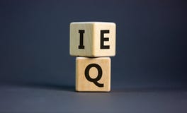 Wooden cubes with the expression `IQ` `Intelligence Quotient` to `EQ` `Emotional Quotient`. Beautiful grey background. Cop