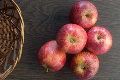 Wooden dark background. Red apples on wooden background, in a basket creating an old and rustic atmosphere. Representation of stock photo Wooden dark background. Red apples on wooden background, in a basket creating an old and rustic atmosphere. Representation of stock photo