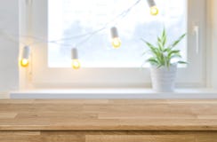 Wooden empty board in front of blurred holiday window background Royalty Free Stock Image Wooden empty board in front of blurred holiday window background Royalty Free Stock Image